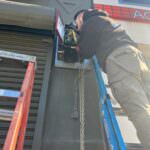 Rainbow Garage Door Service Tech repairing a commercial garage door