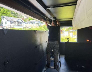 Rainbow Garage Door Service Tech repairing a garage door